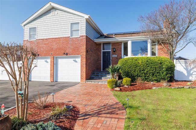 Split level home with driveway, brick siding, a garage, and fence | Image 48
