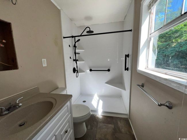 Bathroom with toilet, a stall shower, and vanity | Image 7