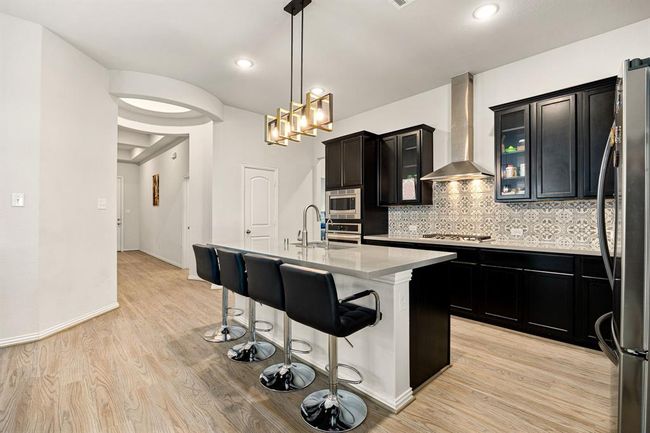 Any chef's dream, this stunning kitchen is perfect for everyday life as well as entertaining family and friends! Extra large kitchen island is perfect for conversation or that much needed space to lay out your party spread for everyone to enjoy! Large windows provide lovely views of your backyard and plenty of natural lighting throughout the day. | Image 9
