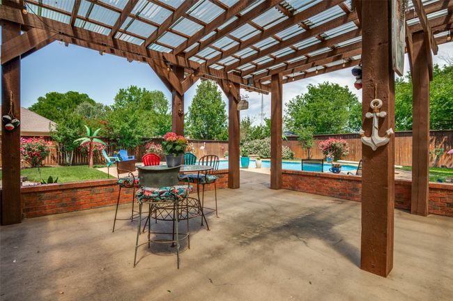 View of patio featuring a fenced backyard, a gorgeous pool, outdoor dining area, and a pergola | Image 30