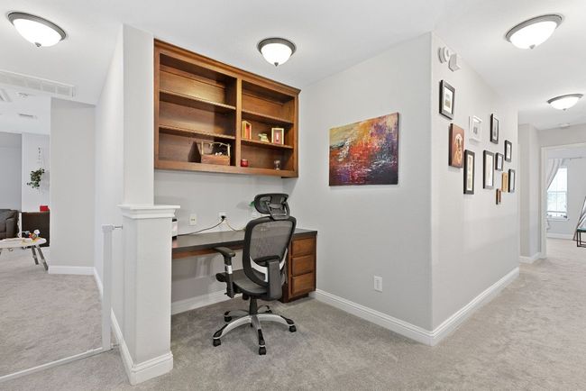 Upstairs hosts a conveniently located second work space with cabinet and shelf storage. | Image 24
