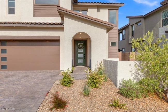 Mediterranean / spanish house with a tiled roof, stucco siding, decorative driveway, fence, and a garage | Image 16