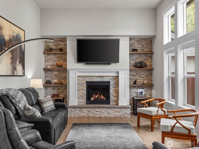 Custom stone wall around the fireplace really makes this space feel homey. | Image 15