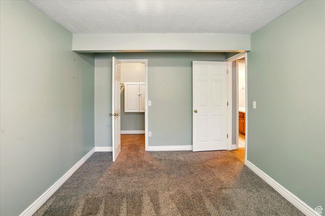 Unfurnished bedroom with carpet flooring, a textured ceiling, and baseboards | Image 18