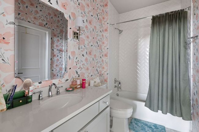 Bathroom with toilet, shower / bath combo, wallpapered walls, and vanity | Image 32