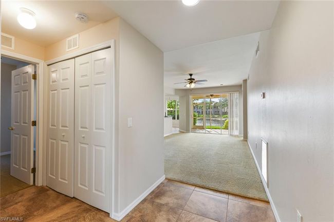 Hallway with carpet, baseboards, and visible vents | Image 11