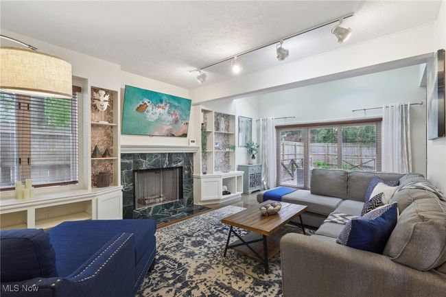 Living area featuring built in shelves, rail lighting, and a fireplace | Image 7