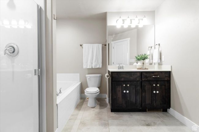 Bathroom featuring a garden tub, a stall shower, toilet, and baseboards | Image 22
