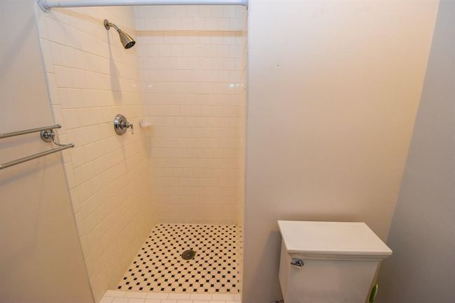 The primary bathroom shower, featuring a sleek and contemporary design with clean lines and high-quality finishes. | Image 28