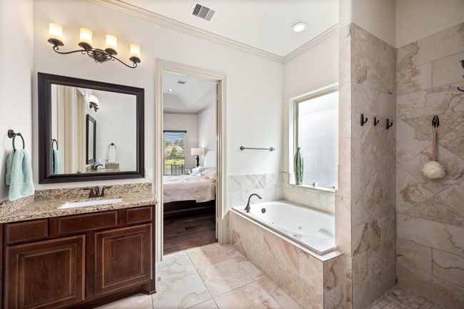 The master bath features a large soaking tub with separate vanities, closets, and walk in shower. | Image 24