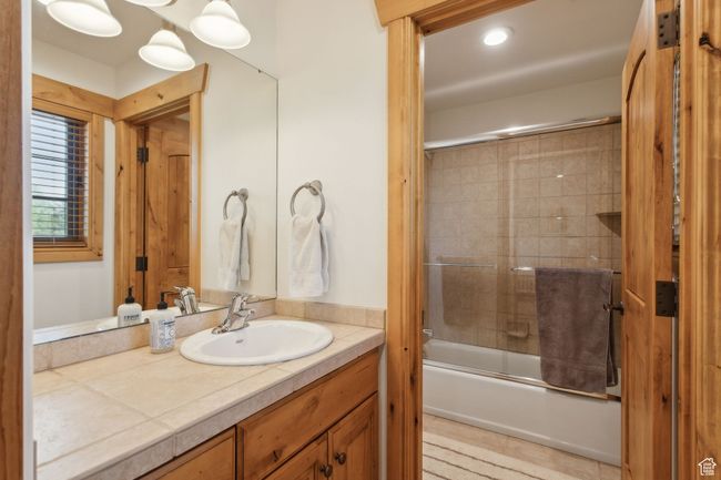 Full bathroom featuring vanity and combined bath / shower with glass door | Image 35
