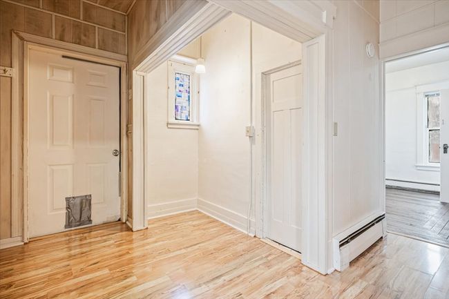 Foyer featuring a baseboard radiator and light hardwood / wood-style flooring | Image 13
