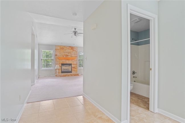 Corridor featuring light tile patterned floors, light colored carpet, and baseboards | Image 5