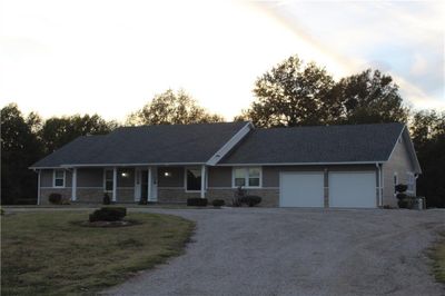 Ranch-style house with a porch and a garage | Image 3