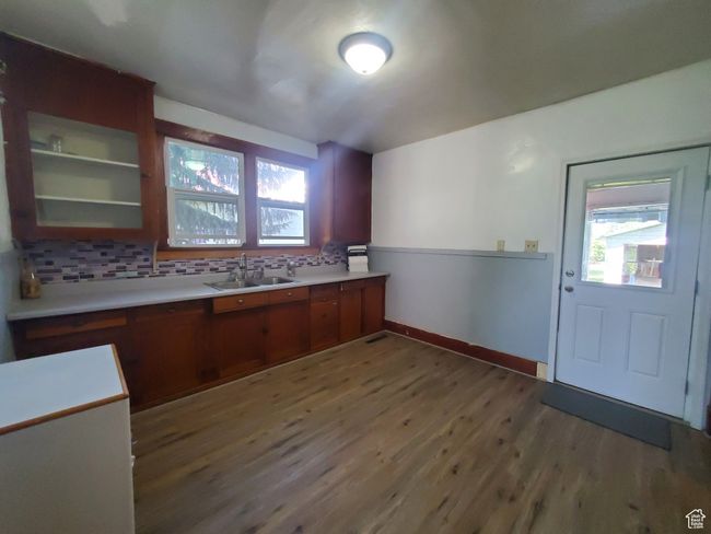 Kitchen with wood finished floors, backsplash, plenty of natural light, and light countertops | Image 5