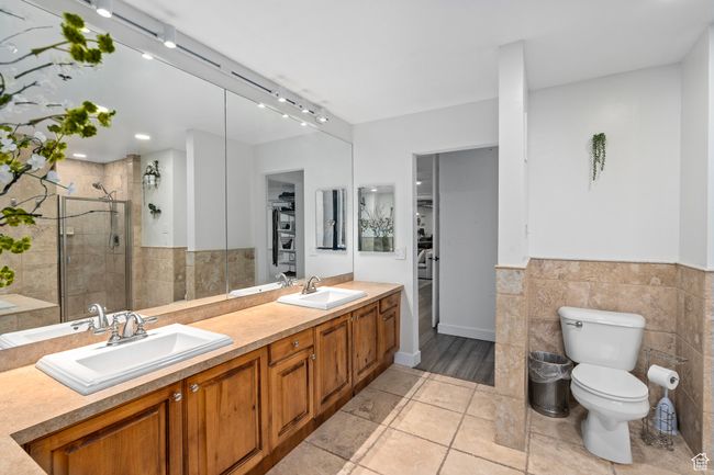 Primary Bathroom with vanity, toilet, an enclosed shower, and tile walls | Image 28