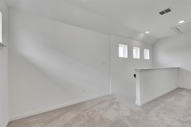Carpeted spare room featuring attic access, recessed lighting, and vaulted ceiling | Image 11