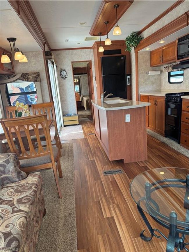 Kitchen with refrigerator, range, hanging light fixtures, a kitchen island, and sink | Image 27