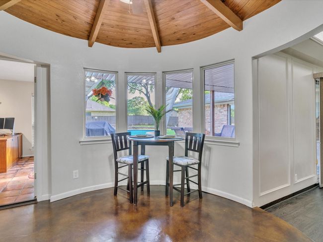 Dining area featuring wood ceiling with exposed beams, baseboards, and concrete flooring | Image 12