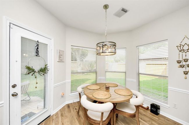 A beautiful wall of windows fills the breakfast area with natural light, creating a bright and cheerful space. The elegant chandelier adds a subtle touch of class, making this cozy nook the perfect place for casual meals—right off the kitchen for easy access. | Image 23