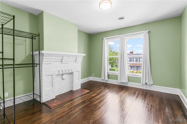 Unfurnished living room with visible vents, baseboards, hardwood / wood-style flooring, and a brick fireplace | Image 23