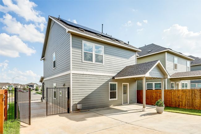 Rear view of property featuring a gate, roof mounted solar panels, a patio, and roof with shingles | Image 39