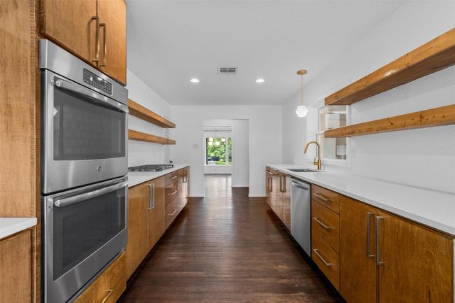 Kitchen featuring open shelves, appliances with stainless steel finishes, a sink, brown cabinets, and recessed lighting | Image 12