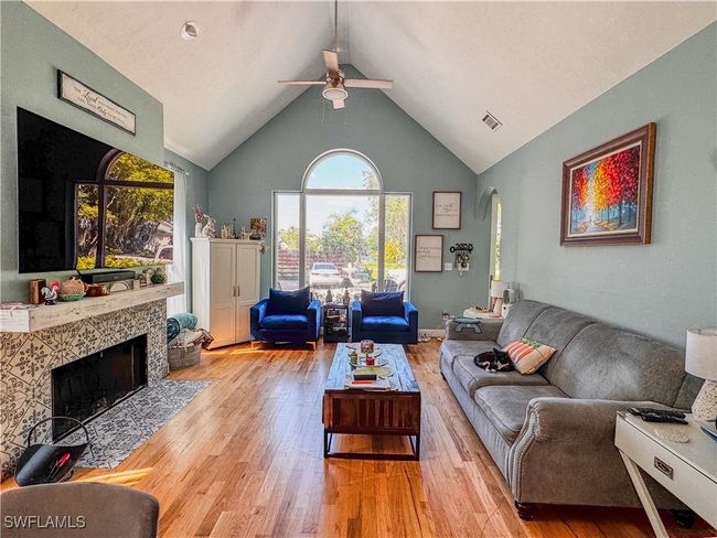 Living area featuring plenty of natural light, a ceiling fan, wood finished floors, and arched walkways | Image 7