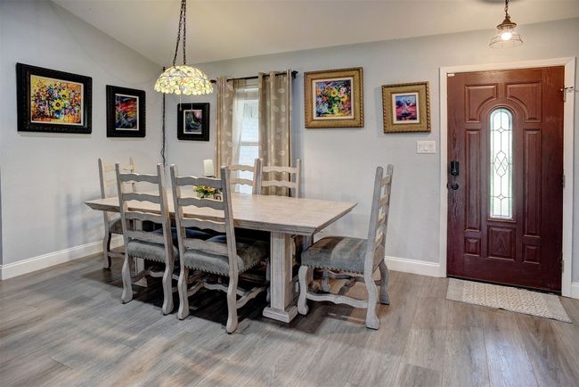Dining area featuring vinyl finished floors and vaulted ceiling | Image 11