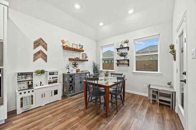 Dining room with wood finished floors, vaulted ceiling, baseboards, and recessed lighting | Image 9