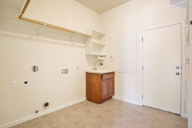 Laundry area featuring electric dryer hookup, hookup for a gas dryer, washer hookup, and light tile patterned floors | Image 35