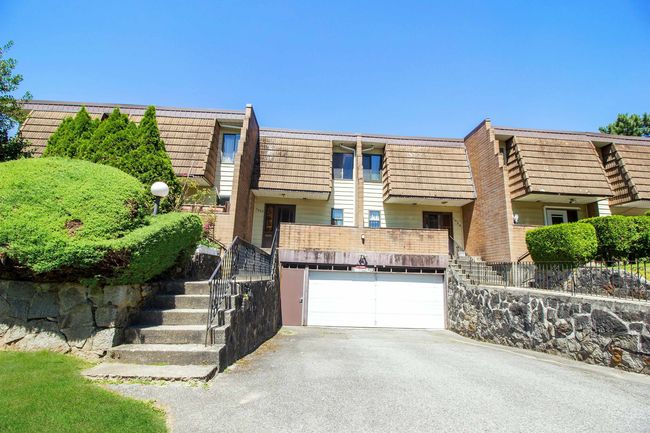 View of front of home with aphalt driveway, mansard roof, stairway, brick siding, and a garage | Image 25