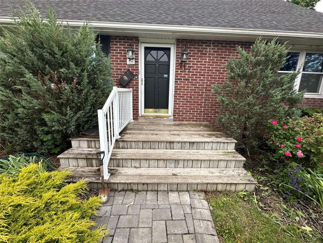 Doorway to property with roof with shingles and brick siding | Image 5