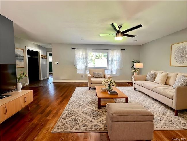 Living room featuring ceiling fan and dark hardwood / wood-style flooring | Image 11