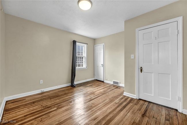Spare room with wood-type flooring, visible vents, and baseboards | Image 38