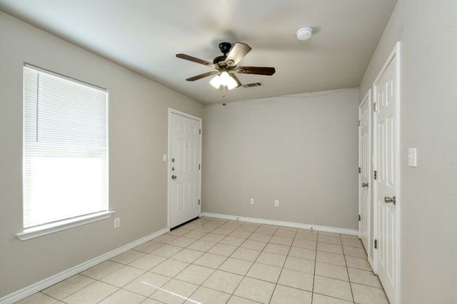 Empty room featuring ceiling fan and light tile patterned floors | Image 10