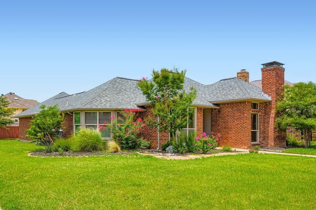 Single story home featuring brick siding, a chimney, and roof with shingles | Image 25