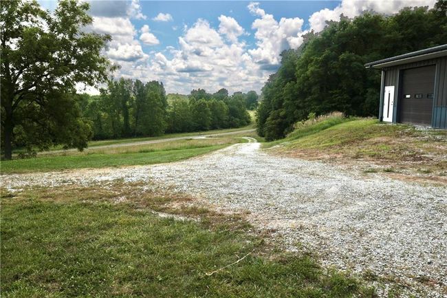 View of dirt / gravel road featuring a view of trees | Image 13