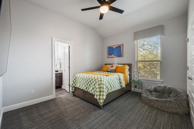 The fourth bedroom has a shared bathroom, large window and ceiling fan. | Image 30
