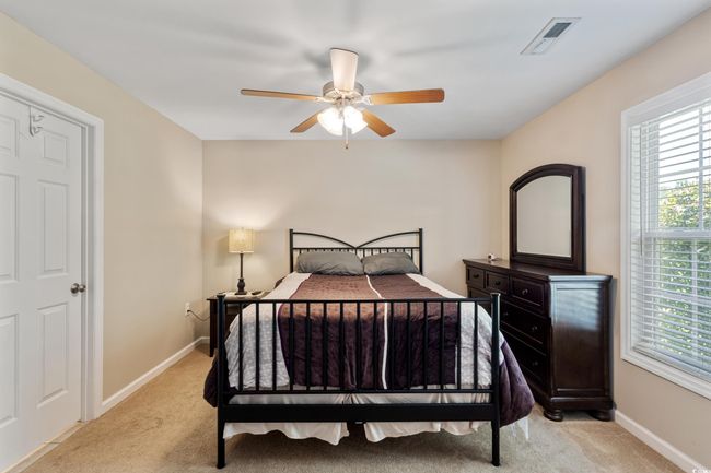 Bedroom with light colored carpet and a ceiling fan | Image 29