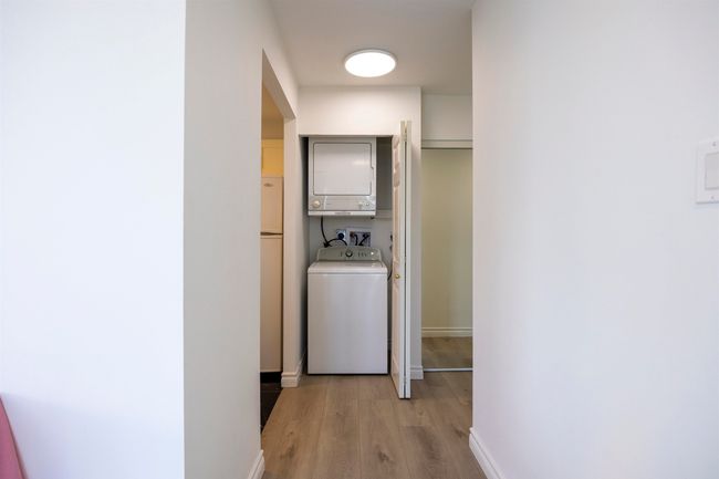 Washroom featuring estacked washer and dryer and light wood-type flooring | Image 14