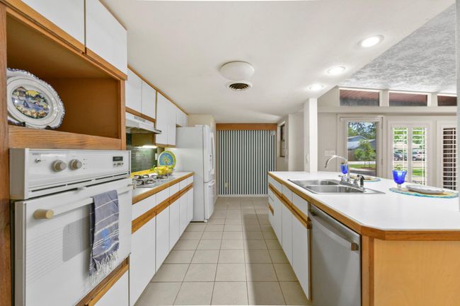 This kitchen features a cozy breakfast nook at one end. | Image 14
