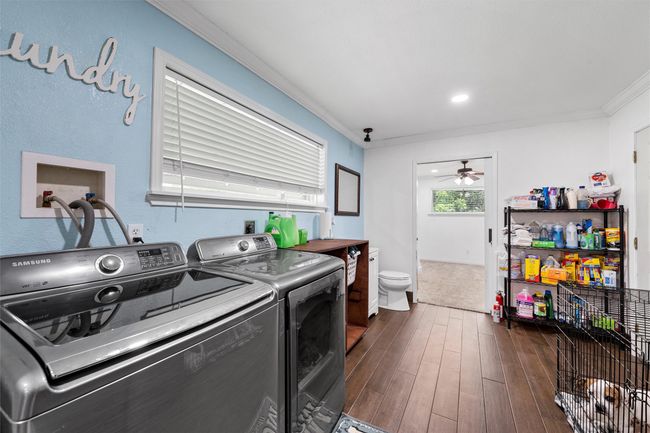 Washroom featuring washing machine and dryer, ornamental molding, dark wood-style flooring | Image 23