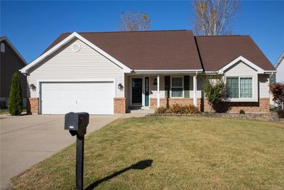 View of front facade featuring a garage, a front lawn, and a porch | Image 1