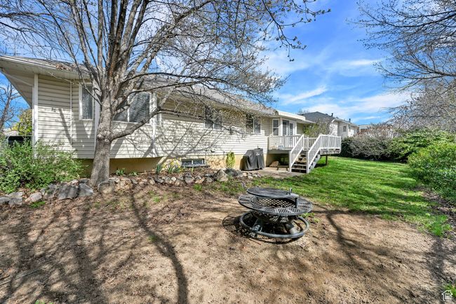 Rear view of property with a yard, a fire pit, and a deck | Image 40
