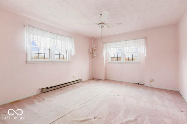unfurnished room featuring a baseboard heating unit, carpet, and ceiling fan | Image 30