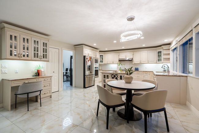 Dining room with light marble finish floors, a chandelier, and recessed lighting | Image 9