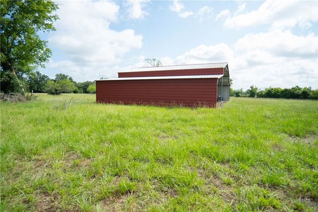 View of yard featuring an outdoor structure and a pole building | Image 25