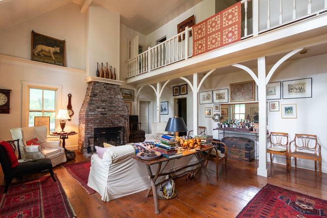 Living room featuring a fireplace, hardwood / wood-style flooring, and high vaulted ceiling | Image 6