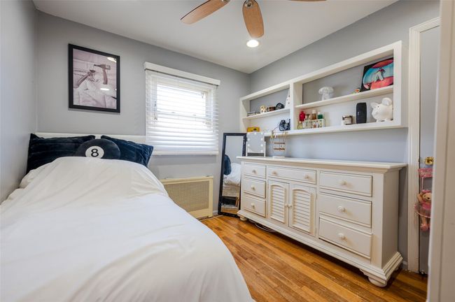Bedroom with light wood-style flooring, radiator heating unit, recessed lighting, and a ceiling fan | Image 14